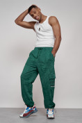 Оптом Широкие спортивные брюки трикотажные мужские зеленого цвета 12932Z в Омске